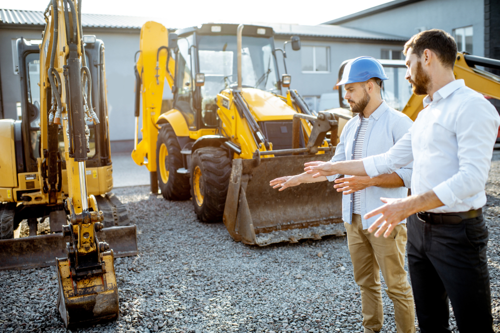 Image of a group of men standing next to a construction vehicle